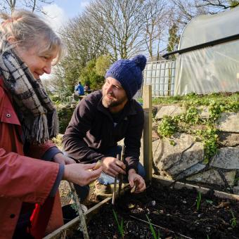 Community member with Eden gardener planting together